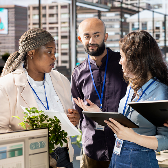 Facility managers discussing maintenance vendor coordination using digital tools.