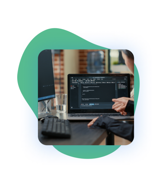 Person working on a laptop displaying code, computer screen in background, framed by a green rounded shape on a light background.